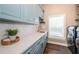 Bright laundry room with modern cabinetry, quartz countertops, and high-end washer and dryer at 180 Keystone Palms Blvd, Tarpon Springs, FL 34688