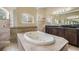 Primary bathroom with a luxurious soaking tub and double vanity at 12314 Lake Jovita Blvd, Dade City, FL 33525