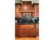 Well-equipped kitchen with dark wood cabinets, granite countertops, and range hood at 29731 Chapel Park Dr, Wesley Chapel, FL 33543