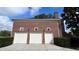 Three-car garage, brick exterior and white doors at 29731 Chapel Park Dr, Wesley Chapel, FL 33543