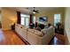 Spacious living room with hardwood floors, sectional sofa, and large TV at 29731 Chapel Park Dr, Wesley Chapel, FL 33543