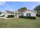 Single-story home with a landscaped lawn and attached garage at 12161 Cavern Rd, Spring Hill, FL 34609