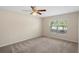 Spacious bedroom with neutral walls and carpet, featuring a large window and ceiling fan at 12161 Cavern Rd, Spring Hill, FL 34609