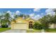 Cute yellow house with a two-car garage and well-manicured lawn at 1122 Vinetree Dr, Brandon, FL 33510