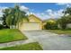 House exterior showcasing a yellow facade, garage, and driveway at 1122 Vinetree Dr, Brandon, FL 33510