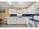 Bright kitchen with white cabinets, dark blue tile backsplash, and stainless steel appliances at 1122 Vinetree Dr, Brandon, FL 33510