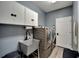 Laundry room with gray washer and dryer, utility sink, and wall cabinets at 1926 Rutherford Dr, Dover, FL 33527