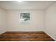 Empty bedroom with wood-look floors and a window at 7585 Abonado Rd, Tampa, FL 33615