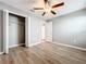 Bedroom with wood-look floors, ceiling fan, and a closet at 10229 Summer Kiss Ave, Riverview, FL 33578