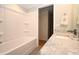 Bright bathroom featuring a tub with white wall surround and vanity with stone countertop and chrome faucet at 5824 11Th St, Zephyrhills, FL 33542