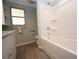 Well lit bathroom with a white tub/shower and updated vanity, cabinets, and flooring at 5824 11Th St, Zephyrhills, FL 33542
