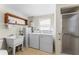 Laundry room with washer, dryer, utility sink and tiled shower at 5824 11Th St, Zephyrhills, FL 33542