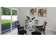 Bright dining area with glass table and four chairs, view of backyard at 6267 Back Forty Loop, Zephyrhills, FL 33541