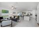 Open living room with gray sofa and adjacent kitchen at 6267 Back Forty Loop, Zephyrhills, FL 33541