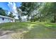 Large grassy backyard with mature trees and a shed at 7249 Berry Rd, Zephyrhills, FL 33540