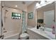 Simple bathroom with shower/tub combo, white vanity, and tile flooring at 7615 Alhambra Dr, Bradenton, FL 34209