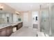 Elegant bathroom with double vanity, large shower, and walk-in closet at 16224 Alpha Grove Pl, Odessa, FL 33556