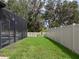 Landscaped backyard with screened enclosure and grassy area at 11431 Thorn Day Ct, San Antonio, FL 33576