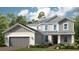 Two story home with gray siding and a three-car garage at 11209 Manor House Ln, Odessa, FL 33556