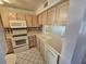 Bright kitchen with white appliances and wood cabinets at 6322 Palma Del Mar S Blvd # 215, St Petersburg, FL 33715