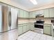 Bright kitchen features stainless steel appliances and light green cabinets at 3809 Windtree Ct, Brandon, FL 33511