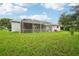 Home's back elevation, featuring a large screened porch at 289 Dandelion Ct, Spring Hill, FL 34606