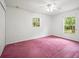 This bedroom features two windows for natural light and pink carpet at 26831 Chianina Dr, Wesley Chapel, FL 33544