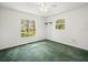 Bright bedroom with green carpet, white walls, and windows providing natural light and outdoor views at 26831 Chianina Dr, Wesley Chapel, FL 33544