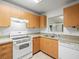 Kitchen with wooden cabinets, countertops and tile flooring with updated appliances at 26831 Chianina Dr, Wesley Chapel, FL 33544
