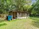 Exterior of a spacious screened-in shed surrounded by a well-maintained yard, perfect for storage or hobbies at 26831 Chianina Dr, Wesley Chapel, FL 33544