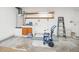 Unfinished utility room with storage shelves, water heater, and cement floor at 26831 Chianina Dr, Wesley Chapel, FL 33544