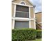 Exterior view of building showing a tan building with white accents, balcony, and landscaping at 9481 Highland Oak Dr # 505, Tampa, FL 33647