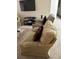 Living room with two armchairs, a large TV, and a glass coffee table at 9481 Highland Oak Dr # 505, Tampa, FL 33647