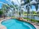 Stunning screened pool with rock waterfall and canal views at 717 Manns Harbor Dr, Apollo Beach, FL 33572