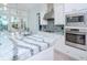 Modern kitchen with white cabinets, large island, and stainless steel appliances at 717 Manns Harbor Dr, Apollo Beach, FL 33572
