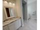 Double vanity bathroom with granite countertop and white cabinets at 717 Manns Harbor Dr, Apollo Beach, FL 33572