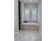 Bathroom with soaking tub, tile flooring and window at 717 Manns Harbor Dr, Apollo Beach, FL 33572