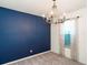 Bedroom with a navy blue accent wall, neutral carpeting, and a window with sheer curtains at 8007 Sequester Loop, Land O Lakes, FL 34637