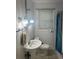 Bathroom with white wainscoting, pedestal sink, and shower with blue curtain at 860 19 N Ave, St Petersburg, FL 33704