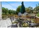 Outdoor deck with patio furniture, including a round table, chairs, and an umbrella, surrounded by lush greenery at 860 19 N Ave, St Petersburg, FL 33704