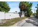 Garage exterior featuring white fencing, palm trees, and an alley, offering privacy and curb appeal at 860 19 N Ave, St Petersburg, FL 33704