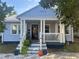 Charming bungalow home with blue siding, a welcoming front porch, and decorative landscaping at 860 19 N Ave, St Petersburg, FL 33704