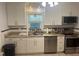 Bright kitchen featuring granite countertops, stainless steel appliances, and white cabinetry at 860 19 N Ave, St Petersburg, FL 33704