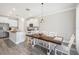 Bright kitchen with white cabinets, kitchen island, and wood dining table at 2848 Gridiron Isle, New Port Richey, FL 34655