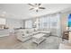 Open concept living room with a sectional sofa, large windows, and a view to kitchen at 2848 Gridiron Isle, New Port Richey, FL 34655