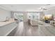 Open-concept living room with tile floors, neutral colors and a large TV at 2848 Gridiron Isle, New Port Richey, FL 34655
