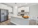 Island kitchen with white cabinets, quartz countertops, and stainless steel appliances at 2848 Gridiron Isle, New Port Richey, FL 34655