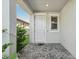 Covered front entry with a white door, brick pavers, and lush landscaping at 2848 Gridiron Isle, New Port Richey, FL 34655