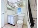 Bathroom with a vanity and large mirror, toilet, and a shower-tub combo with a dark-toned shower curtain at 11920 Boynton Ln # 11920, New Port Richey, FL 34654