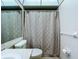 A bathroom features a vanity sink, toilet, and shower/tub combination with a textured curtain at 11920 Boynton Ln # 11920, New Port Richey, FL 34654